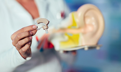 doctor holding hearing aid